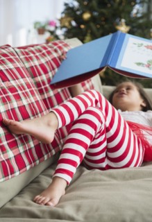 Hispanic girl reading on sofa
