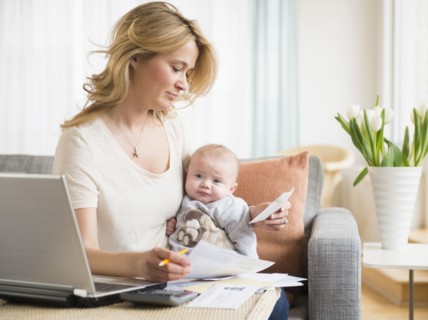 Caucasian mother with baby paying bills