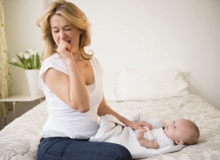 Yawning Caucasian mother with baby
