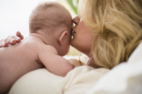 Caucasian mother kissing baby