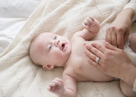 Caucasian mother changing baby's diaper