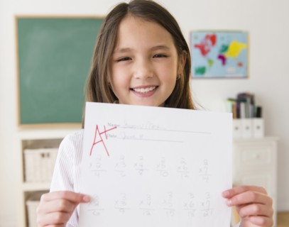 Mixed race girl holding paper with A+ grade