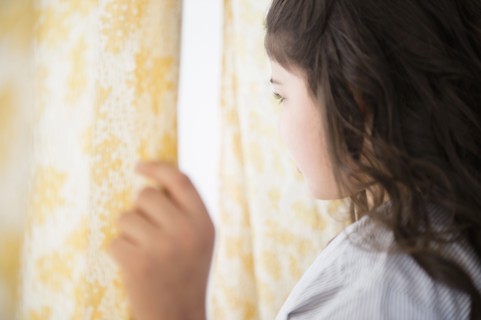 Hispanic girl looking out window