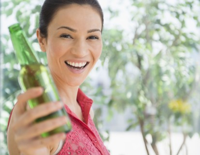 Caucasian woman holding bottle of beer