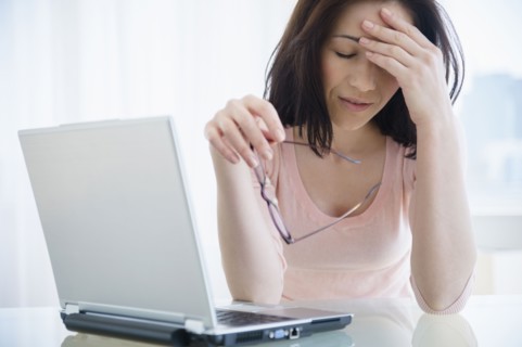 Frustrated Caucasian woman using laptop