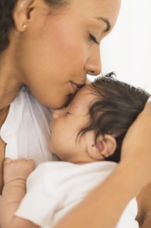 Hispanic mother kissing infant son