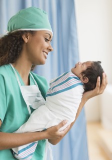 Hispanic doctor holding newborn in hospital