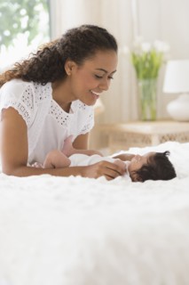Hispanic mother playing with infant