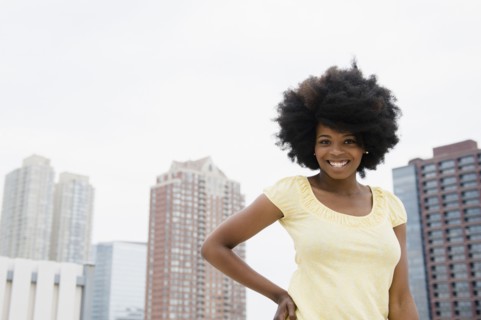 Mixed race woman smiling on urban rooftop