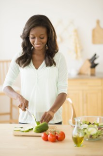 Black woman chopping vegetables in kitchen