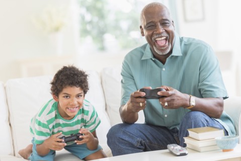 Boy playing video games with grandfather