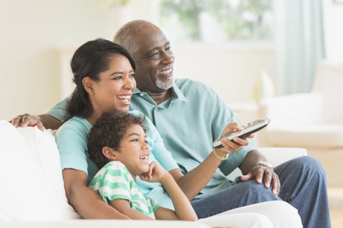 Three generations of family watching tv