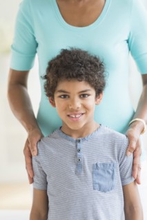 Smiling boy standing with mother