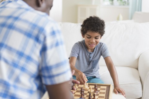 Boy playing chess with grandfather