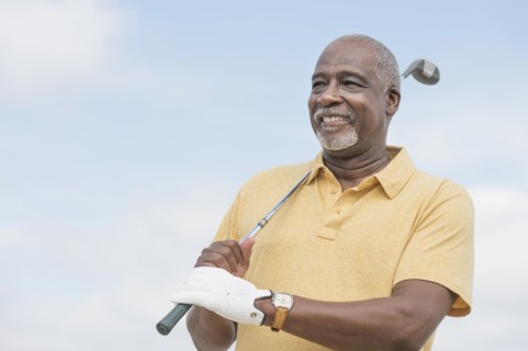 Black man playing golf outdoors