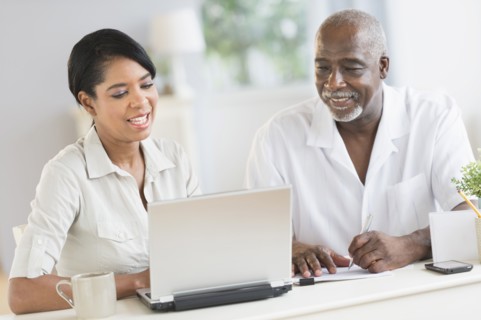 Black father and daughter using laptop