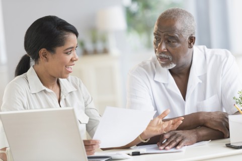 Black father and daughter using laptop