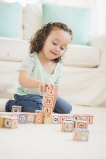 Mixed race girl playing with wooden blocks