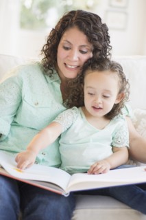 Mixed race mother reading with daughter