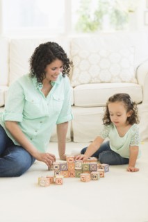 Mixed race mother and daughter playing with wooden blocks