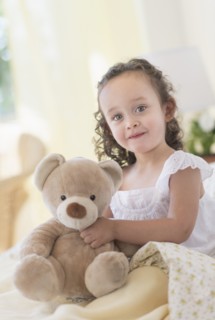 Mixed race girl holding teddy bear