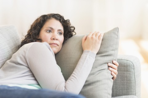 Hispanic woman relaxing on sofa