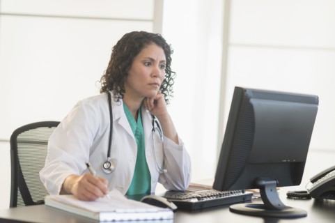Hispanic doctor working in office