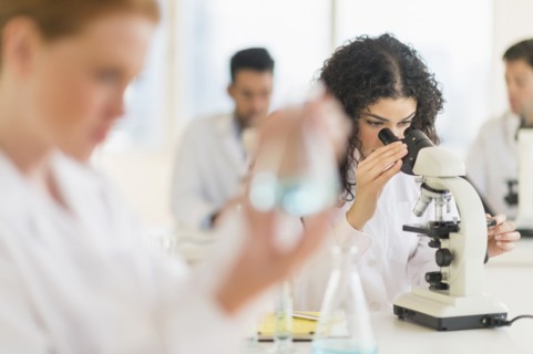 Scientist using microscope in laboratory
