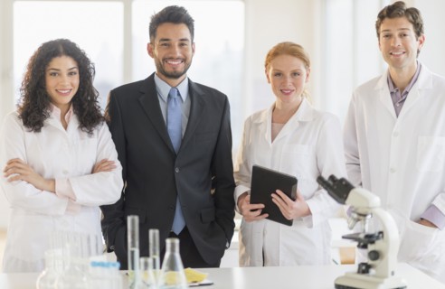 Scientists and businessman smiling in laboratory