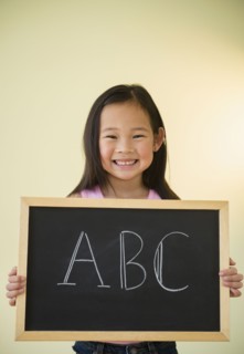 Korean girl holding chalkboard with ABC text