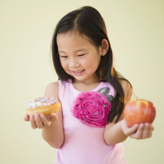 Korean girl choosing between apple and donut