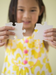 Korean girl connecting jigsaw pieces