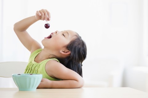 Korean girl eating bowl of fruit