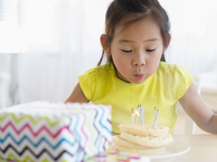 Korean girl blowing out candles on birthday cake