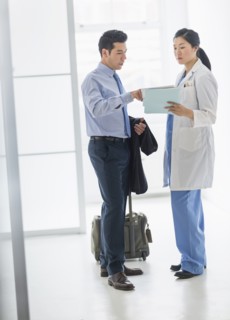 Doctor and businessman talking in hospital