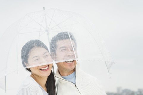 Couple laughing under umbrella