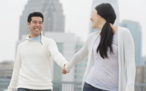 Couple holding hands in city