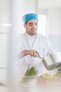 Mixed race chef cooking in restaurant