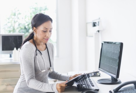 African American doctor looking down at clipboard