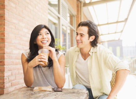 Couple enjoying iced coffee at sidewalk cafe