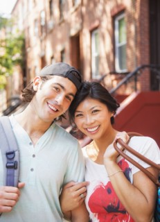 Couple smiling outside brownstones