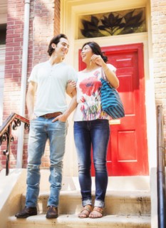 Couple standing on front stoop with house key