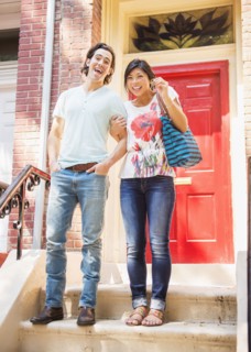 Couple standing on front stoop with house key