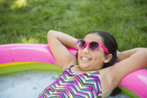 Mixed race girl relaxing in wading pool