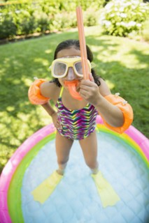 Mixed race girl wearing snorkeling gear in wading pool