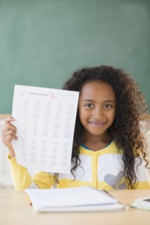 Mixed race student showing off A plus grade in classroom