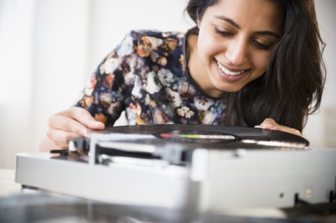 Close up of Asian woman using record player