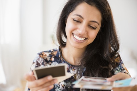 Smiling Asian woman looking at photographs