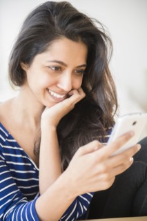Close up of Asian woman text messaging with cell phone
