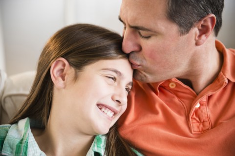 Caucasian father kissing daughter's forehead